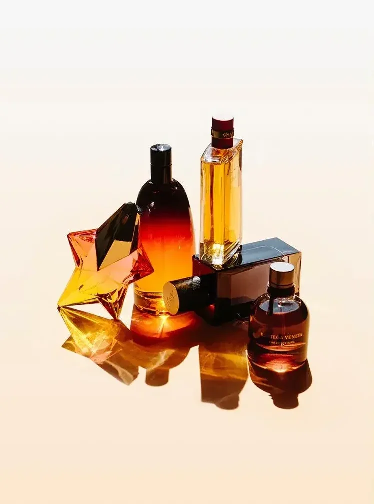 Fotografía de bodegón con perfumes en tonos cálidos para dirección de arte.