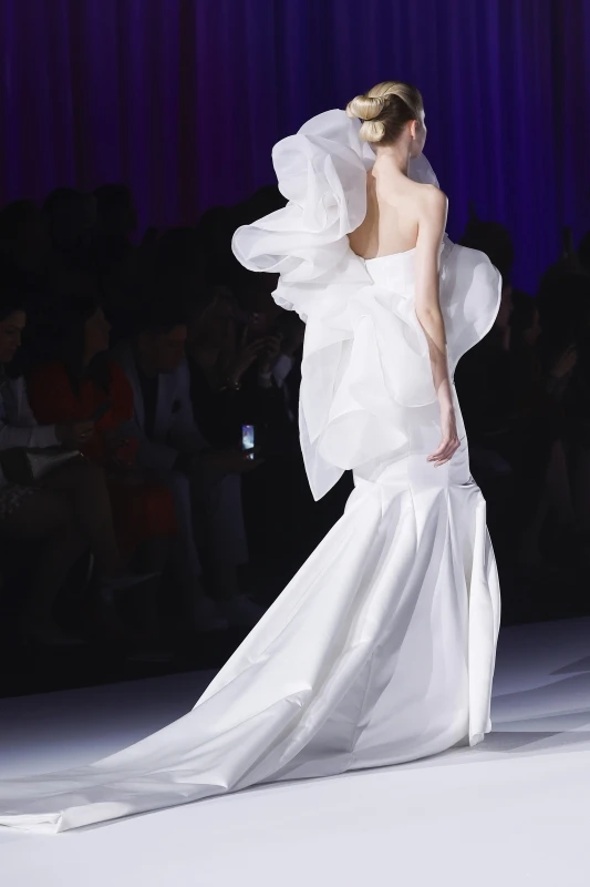 Diseño nupcial de Ronald Cáceres para ESDI en Barcelona Bridal Fashion Week 2026 con volumen escultórico y cola larga.