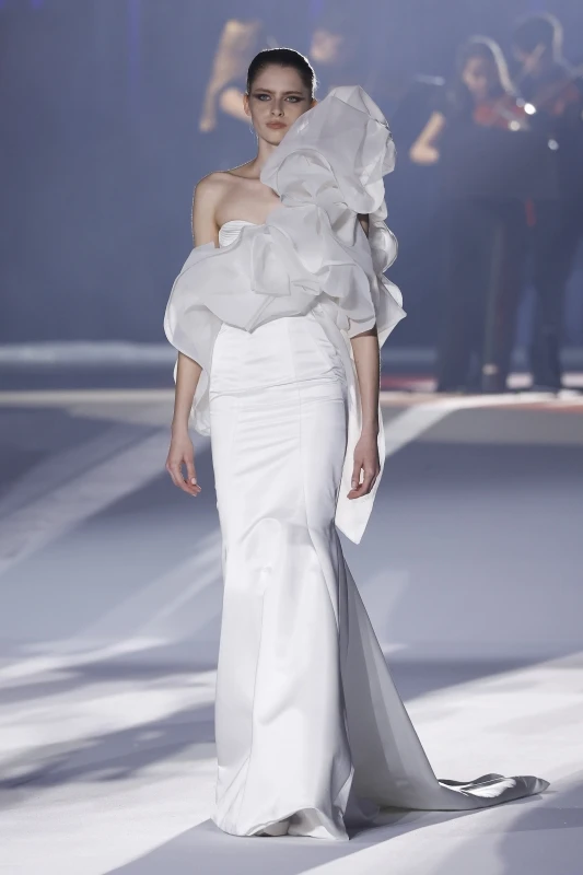 Diseño nupcial de Ronald Cáceres para ESDI en Barcelona Bridal Fashion Week 2026 con volumen escultórico y cola larga.
