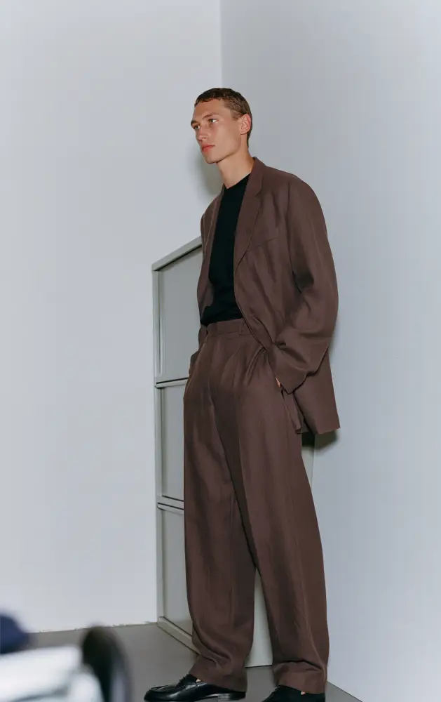 modelo masculino posando con traje a medida marrón